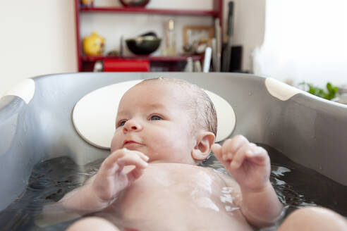 Ein kleines Mädchen beim Baden in einer Küche, Lomener, Bretagne, Frankreich. - CAVF64132