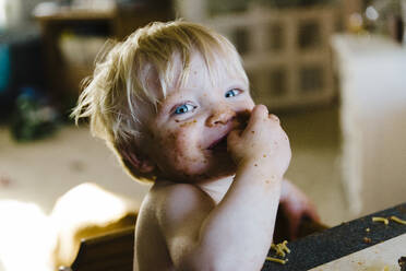 Toddler laughing with spaghetti all over his face. - CAVF64173