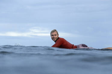 Man lying on surfboard on the sea - CAVF64313