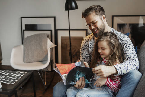 Father and daughter reading book stock photo