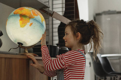 Girl looking at globe - JOHF02026