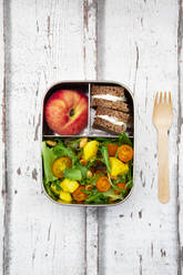 Close-up of lunchbox with mango salad, rye bread sandwich and peach - LVF08295