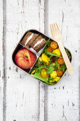 Close-up of lunchbox with mango salad, rye bread sandwich and peach - LVF08297