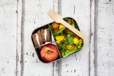 Nahaufnahme einer Lunchbox mit Mangosalat, Roggenbrot und Pfirsich - LVF08298