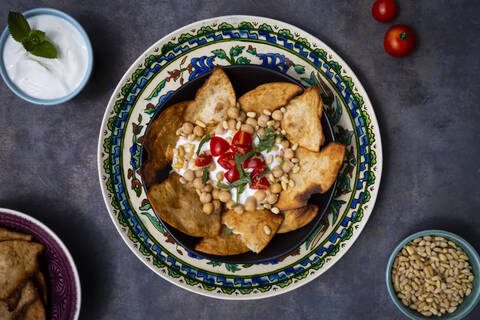 Schüssel mit levantinischem Fatteh, mit Fladenbrot, Tomaten und Kichererbsen, lizenzfreies Stockfoto