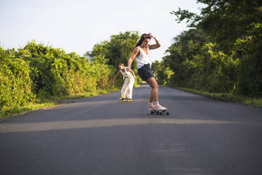 Junge Frauen beim Skateboarden im Sommer - CAVF64433