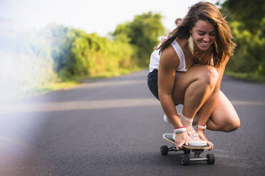 Junge Frauen beim Skateboarden im Sommer - CAVF64434