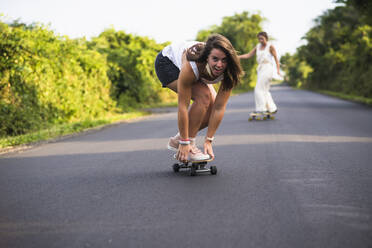 Junge Frauen beim Skateboarden im Sommer - CAVF64436