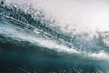 Close up of powerful backlit wave breaking against clear sky - CAVF64472