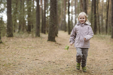 Porträt eines lächelnden kleinen Mädchens im Wald - EYAF00483