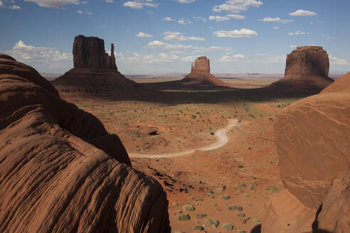 Wolken beschatten einen Teil der legendären Felsformationen im Monument Valley, AZ - CAVF64552