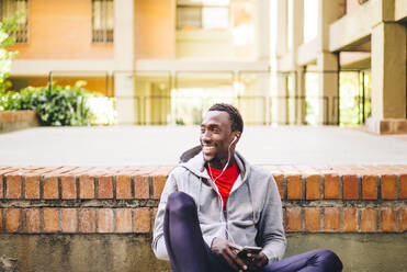 Young sportive man taking a break from workout using his smartphone - OCMF00774