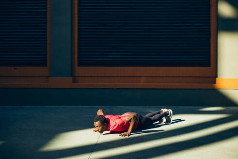 Young sportive man doing pushups outdoors - OCMF00776