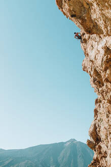Gezogene Rückansicht eines männlichen Kletterers an der Wand mit El Teide im Hintergrund - CAVF64611