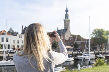 Niederlande, Zeeland, Veere, Frau beim Fotografieren der Altstadt - CHPF00595