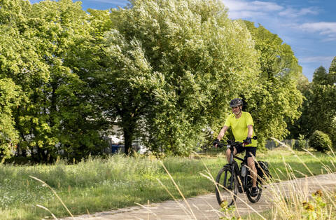 Älterer Mann auf einer Tour mit einem E-Bike, lizenzfreies Stockfoto