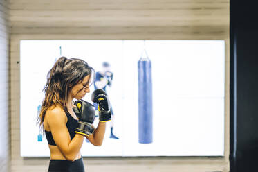 Weiblicher Boxer beim Training im Fitnessstudio - CJMF00040