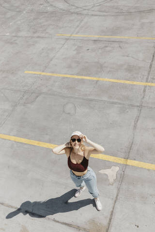 Lächelnde junge Frau auf einem Parkplatz, lizenzfreies Stockfoto