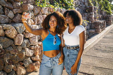 Porträt von zwei jungen Frauen, die ein Selfie mit einem Smartphone machen - MPPF00041