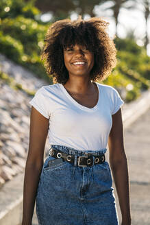 Portrait of smiling young woman with smartphone in her pocket - MPPF00051