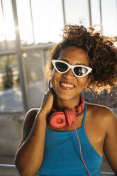 Porträt einer glücklichen jungen Frau mit Sonnenbrille - MPPF00070