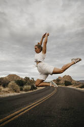 Frau springt auf Straße, Joshua Tree National Park, Kalifornien, USA - LHPF01019