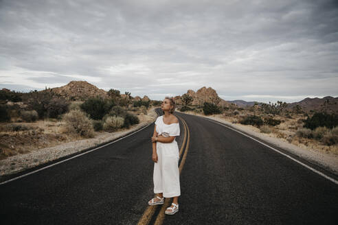 Frau steht auf der Straße, Joshua Tree National Park, Kalifornien, USA - LHPF01021