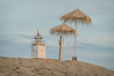 Niederlande, Südholland, Noordwijk, Leuchtturm und Sonnenschirme am Sandstrand - KEBF01335