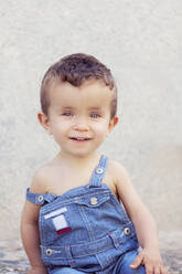 Portrait of little boy wearing denim dungarees in summer - XCF00271