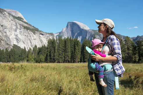 Mutter trägt ihre Tochter in einer Babytrage, Yosemite National Park, Kalifornien, USA - GEMF03197