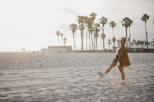 Glückliche junge Frau am Strand, Venice Beach, Kalifornien, USA - LHPF01062