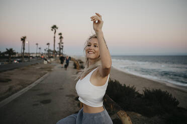 Glückliche junge Frau am Strand, Huntington Beach, Kalifornien, USA - LHPF01064
