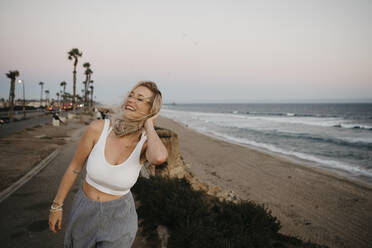 Glückliche junge Frau am Strand, Huntington Beach, Kalifornien, USA - LHPF01065