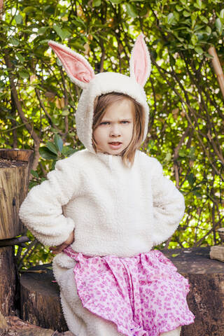 Porträt eines wütenden kleinen Mädchens im Osterhasenkostüm, lizenzfreies Stockfoto