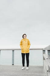 Young woman wearing yellow rain coat - NAF00119