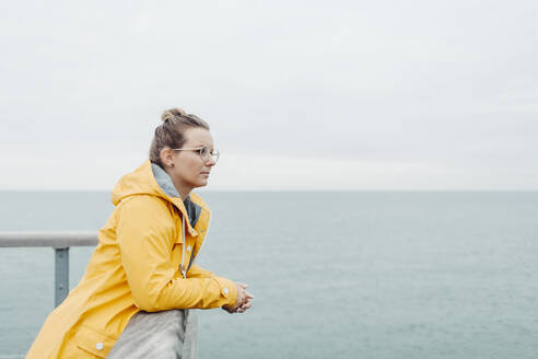 Young woman wearing yellow rain coat - NAF00120