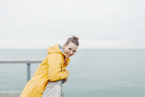 Young woman wearing yellow rain coat stock photo