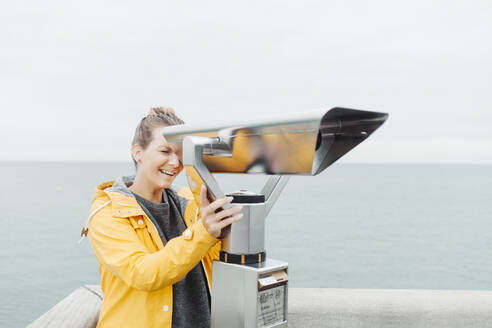 Young blond woman looking through telescope - NAF00127