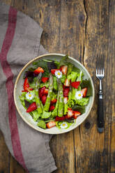 Close-up of salad with green asparagus, strawberries and daisies - LVF08315