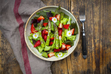 Nahaufnahme von Salat mit grünem Spargel, Erdbeeren und Gänseblümchen - LVF08316