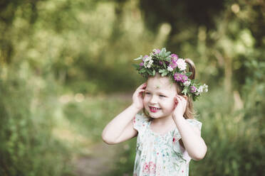 Porträt eines lächelnden kleinen Mädchens mit Blumenkranz - EYAF00525