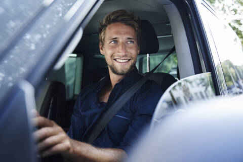 Smiling young man in car stock photo