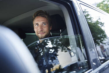 Porträt eines selbstbewussten jungen Mannes im Auto - PNEF02101