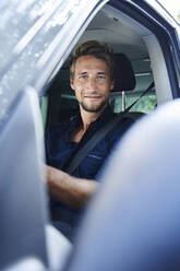 Portrait of confident young man in car - PNEF02103