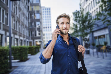 Confident young businessman on the phone in the city - PNEF02109