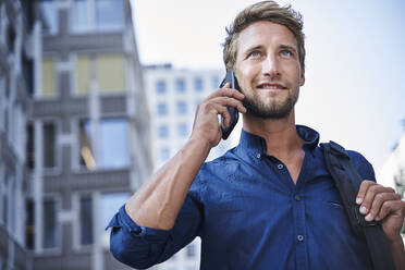 Confident young businessman on the phone in the city - PNEF02110