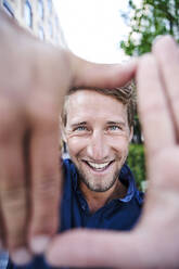 Portrait of happy young man making a finger frame - PNEF02127