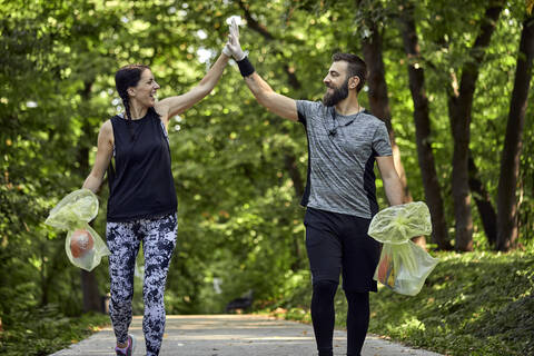 Glückliches Paar beim Joggen auf einem Waldweg, lizenzfreies Stockfoto