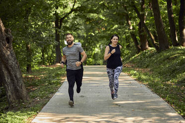 Sportliches Paar beim Laufen auf einem Waldweg - ZEDF02627