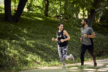 Sportliches Paar beim Laufen auf einem Waldweg - ZEDF02633